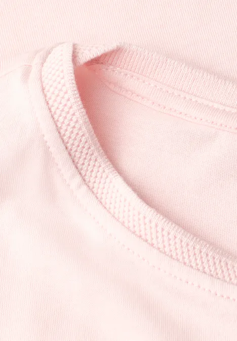 Nahaufnahme eines rosa T-Shirts mit geripptem Rundhalsausschnitt.